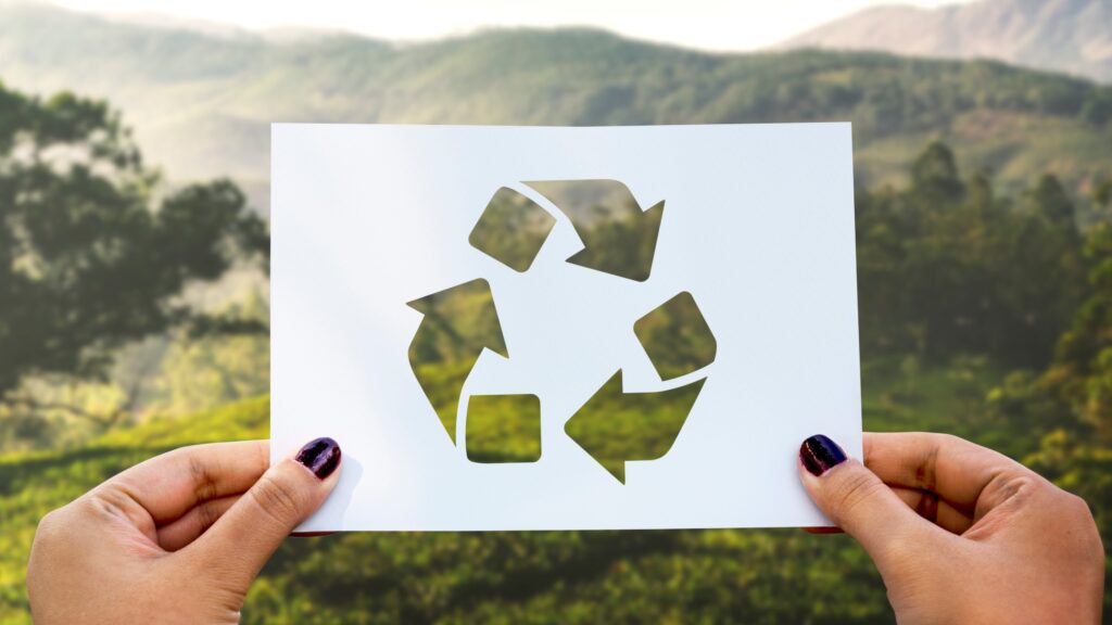 Recycling symbol cut out of perforated paper